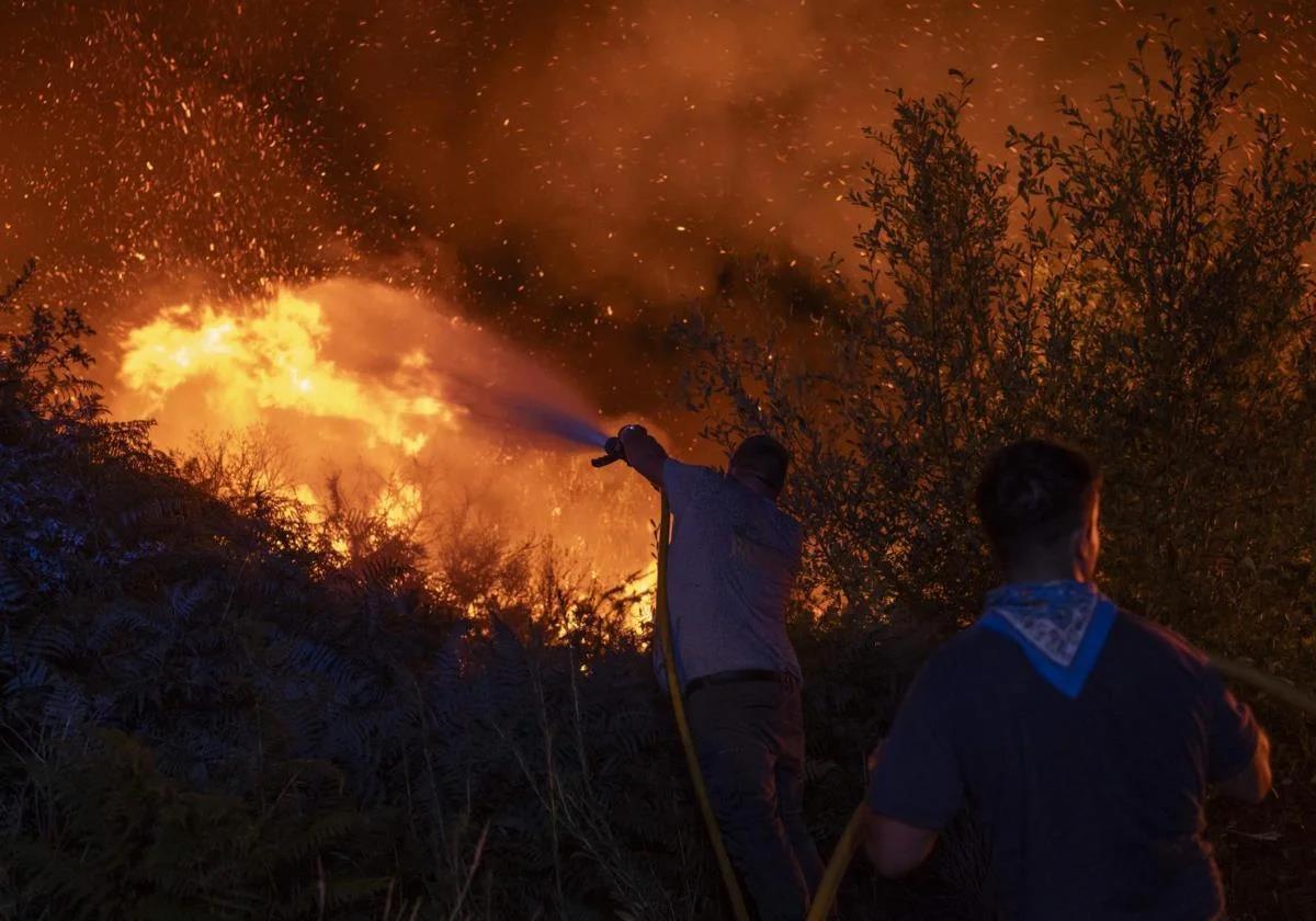 Several residents helping to extinguish the forest fire in Carballeda de Avia (Ourense).